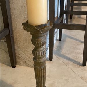 Tall candle holder with candle.